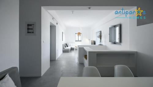 a white living room with a table and chairs at Antiparos Homes in Antiparos Town