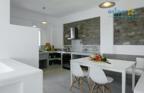 a kitchen with a white table and white chairs at Antiparos Homes in Antiparos Town