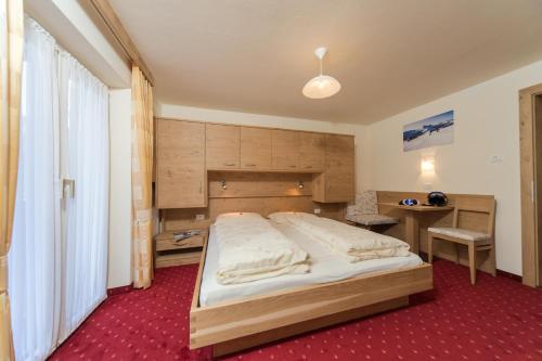 a bedroom with a large bed and a desk at Kedul Lodge in Santa Cristina in Val Gardena