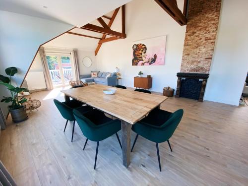 a dining room with a wooden table and chairs at Luxurious historical Loft close to the beach! in Wassenaar
