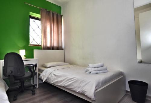 Cette chambre comprend un lit, un bureau et une chaise. dans l'établissement City Living Suite TK 1 Rm 4, à San Ġiljan