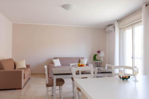 a white living room with a table and chairs at Appartamento Matteotti in Mazara del Vallo