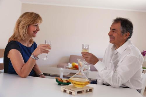 a man and woman sitting at a table drinking champagne at Appartamento Matteotti in Mazara del Vallo