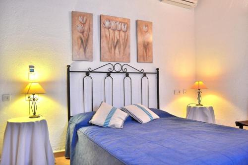 a bedroom with a bed with blue sheets and two lamps at 041 Finca Can Roig Gran ET0309 by Mallorca Charme in Pollença