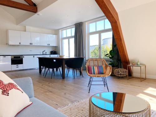 a living room with a couch and a table at Luxurious historical Loft close to the beach! in Wassenaar