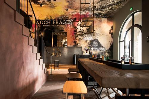 a restaurant with a long bar with stools at Hotel / Weingut Meintzinger in Frickenhausen