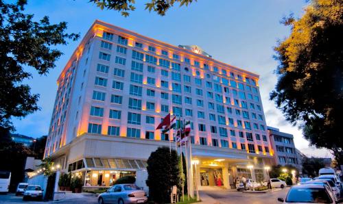 un edificio alto con coches estacionados frente a él en Akgun Istanbul Hotel en Estambul