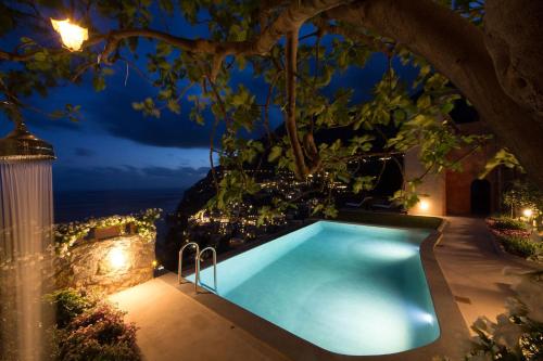 an outdoor swimming pool at night with lights at Amore Rentals - Villa Angelina in Positano