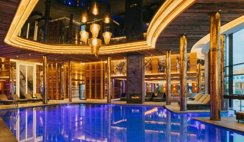a pool in a hotel lobby with a chandelier at Ortner's Resort in Bad Füssing