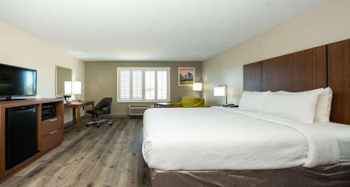 a hotel room with a large bed and a flat screen tv at Best Western Houston Bush IAH Intercontinental Airport Inn in Humble