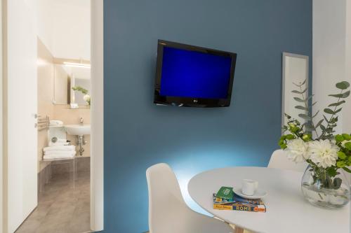 ローマにあるアウレリア 429 ファイン タウン ハウスのリビングルーム(テーブル、青い壁のテレビ付)