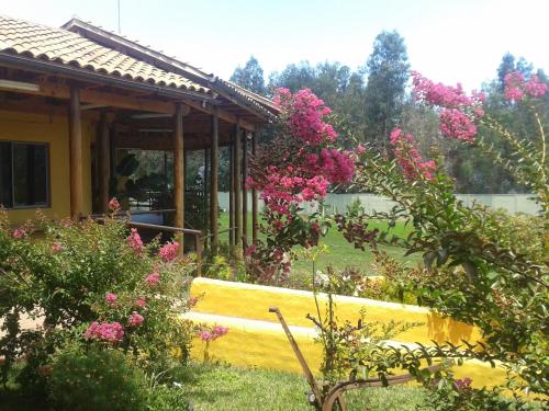a garden with pink flowers in front of a house at Hotel Ontiveros in San Fernando