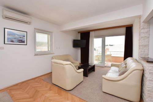 a living room with two couches and a tv at Apartments Danica in Primošten