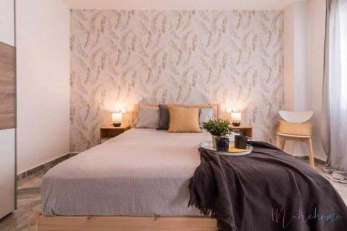 una camera da letto con un grande letto con due luci sopra di Apartamento tranquilo en pleno centro con garaje a Huelva