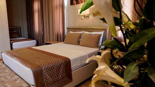 una habitación de hotel con una cama y una planta en Othello Hotel, en Mersin