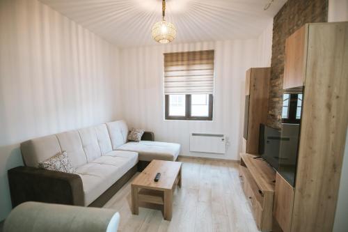 salon z białą kanapą i stołem w obiekcie Kraljevi Konaci -Apartmani Bajka w mieście Kopaonik