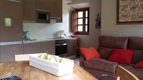 a kitchen and a living room with a couch and a table at Apartamentos Rurales Los Mazos in Boal