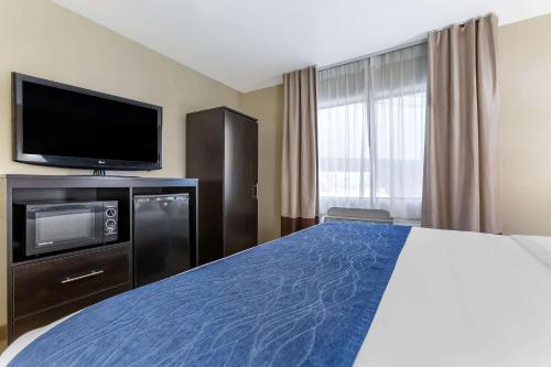a hotel room with a bed and a flat screen tv at Comfort Inn & Suites Surprise Near Sun City West in Surprise