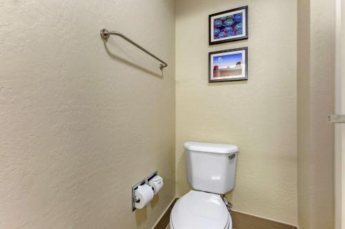 a bathroom with a toilet and two pictures on the wall at Comfort Inn & Suites Surprise Near Sun City West in Surprise