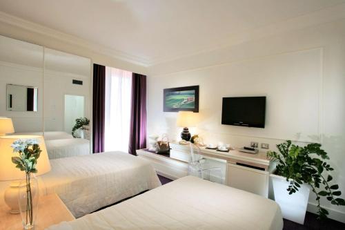 a hotel room with two beds and a flat screen tv at Etrusco Arezzo Hotel - Sure Hotel Collection by Best Western in Arezzo