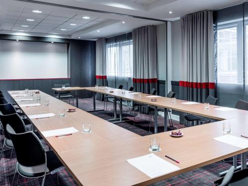 a conference room with tables and chairs and a whiteboard at Mercure Paris la Défense Grande Arche in Nanterre