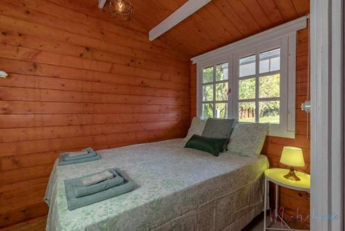 1 dormitorio con 1 cama en una cabaña de madera en Bungalow espectacular garaje piscina y jacuzzi, en Aljaraque