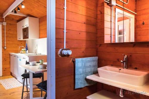 Łazienka z drewnianymi ścianami, umywalką i stołem w obiekcie Bungalow espectacular garaje, piscina y jacuzzi w mieście Aljaraque