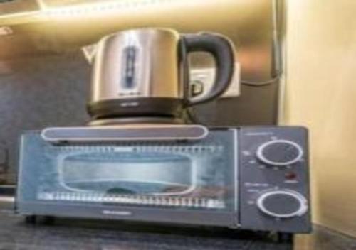 a coffee cup sitting on top of a microwave at KLIA Glorybnb Bell Suites in Sepang