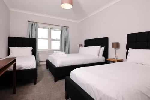 a hotel room with two beds and a window at Michelangelos - Rooms, Restaurant & Bar in Gateshead