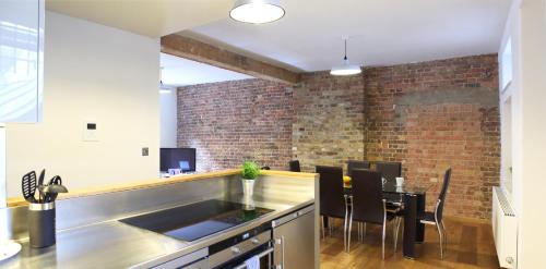 a kitchen and dining room with a brick wall at Shoreditch London Apartments in London