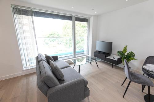 a living room with a couch and a tv at Shoreditch London Apartments in London