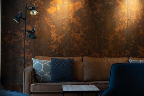 a living room with a brown couch and a wall at Zleep Hotel Copenhagen City in Copenhagen