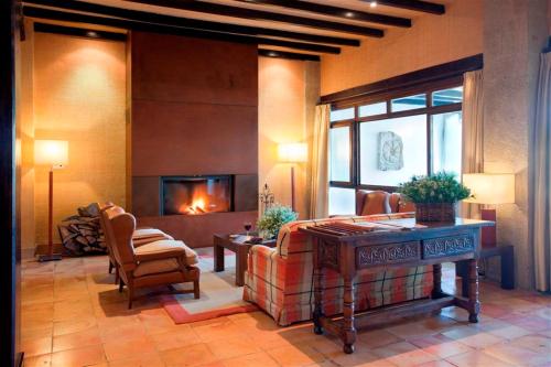 a living room with a fireplace and a couch and a chair at Parador de Sos del Rey Católico in Sos del Rey Católico