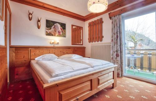 a bedroom with a bed and a large window at Hotel Kollerhof in Aich