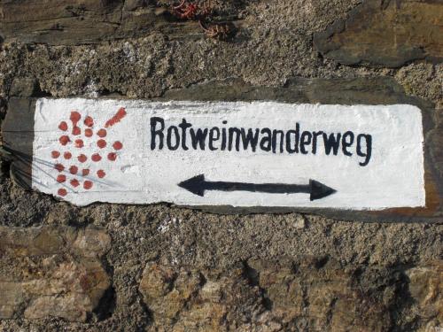 a sign on the side of a brick wall with arrows at Hotel Ännchen in Bad Neuenahr-Ahrweiler