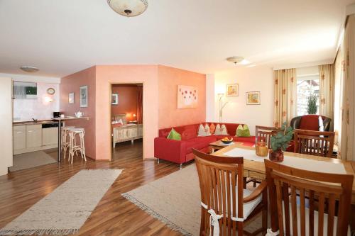 ノイシュティフト・イム・シュトゥーバイタールにあるChalet Claudiaのリビングルーム(赤いソファ、テーブル付)