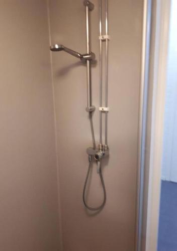 a shower stall with a hanger on a wall at STF Kalix Vandrarhem in Kalix