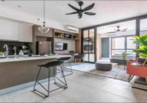 a kitchen with two bar stools and a ceiling fan at KLIA Glorybnb Bell Suites in Sepang