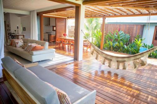 a living room with a couch and a hammock at Excelente casa, pé na areia, no melhor de Arraial! in Arraial d'Ajuda