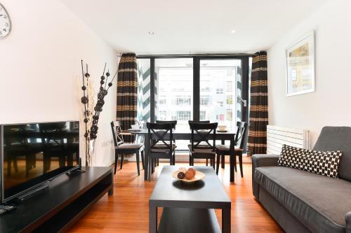 a living room with a couch and a table at Shoreditch London Apartments in London