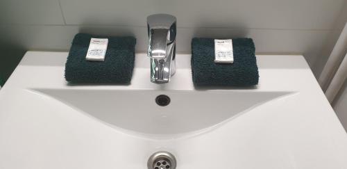 a bathroom sink with two towels and a toothbrush at James Sun Beach Apartment in Ostend