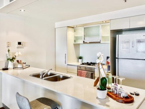 a kitchen with white cabinets and a sink at Amazing River View - 3 Bedroom Apartment - Brisbane CBD - Netflix - Fast Wifi - Carpark in Brisbane