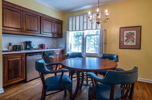 a kitchen with a wooden table and blue chairs at Century Suites Hotel in Bloomington