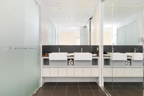 布里斯班Amazing River View - 3 Bedroom Apartment - Brisbane CBD - Netflix - Fast Wifi - Carpark的一间带3个盥洗盆、镜子和淋浴的浴室