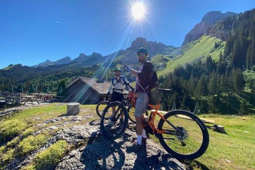two men standing next to a bike on a mountain at CHALET LYOBA in Le Grand-Bornand