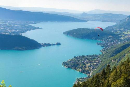 a person in a parachute flying over a lake at CHALET LYOBA in Le Grand-Bornand