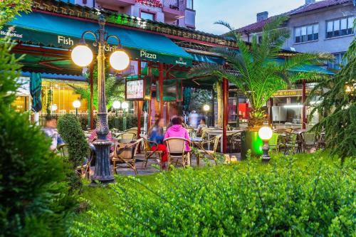 a group of people sitting at an outdoor restaurant at Saint George Hotel & Medical Spa in Pomorie