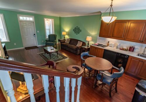 a living room with a table and a kitchen at Century Suites Hotel in Bloomington