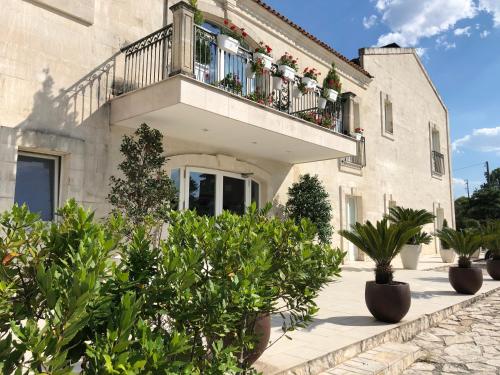 a building with a balcony with potted plants on it at Hotel Cave Del Sole in Matera