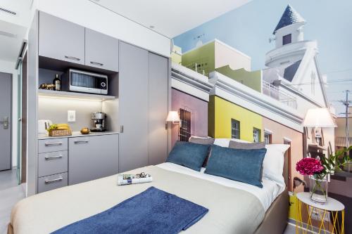 a bedroom with a large white bed with blue pillows at VISIONAPARTMENTS Rue des Communaux - contactless check-in in Vevey